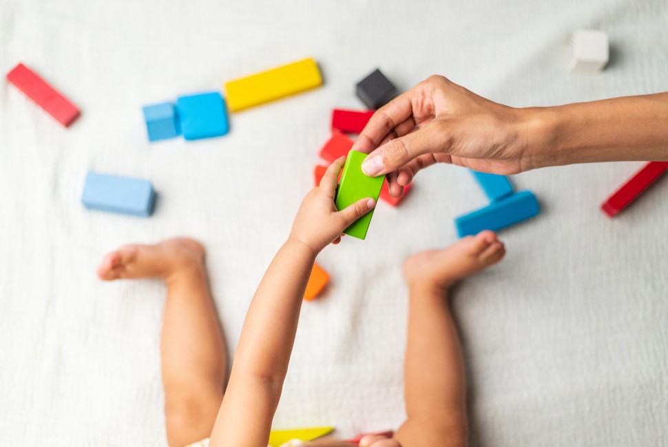 Infant playing with colored blocks